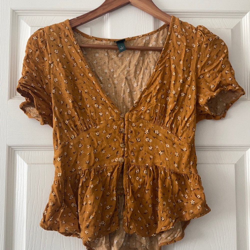 Mustard top with floral pattern. Crop top length